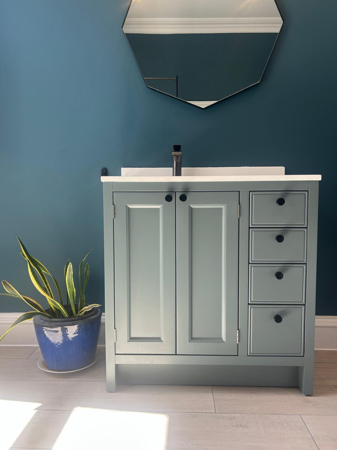 Sage green vanity unit with basin and hexagonal mirror fitted by Pentaburgh in an Edinburgh bathroom